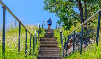 A girl running up concrete stairs on top of a mountain