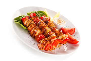 Roast meat with vegetables on stick on white background