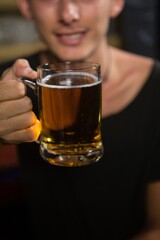 Man holding a mug of beer in bar