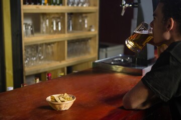 Man having a mug of beer at counter