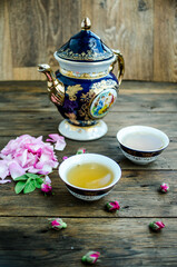 cup of tea with rose on white wooden table