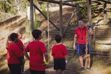 Trainer instructing kids in the boot camp