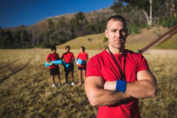 Naklejka premium Trainer standing with arms crossed in the boot camp