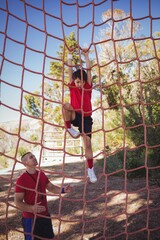 Trainer instructing boy during obstacle course training