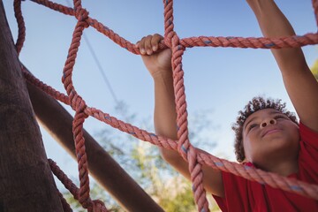 Boy climbing a net during obstacle course training