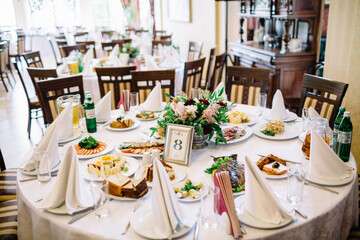 Number eight put in a steel frame stands before the bouquet in the center of dinner table