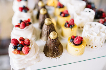 Sweets decorated with berries and served on glass dish