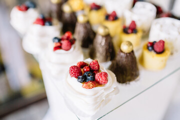 Sweets decorated with berries and served on glass dish