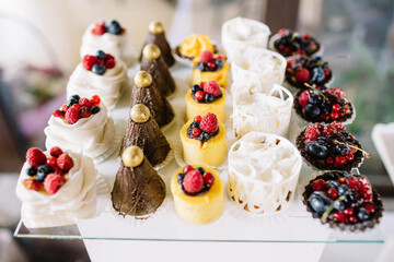 Sweets decorated with berries and served on glass dish