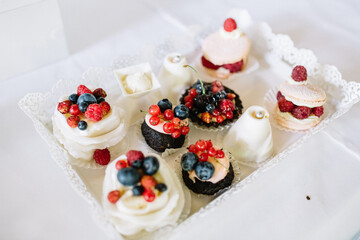 Sweets decorated with berries and served on glass dish