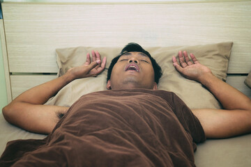 Men sleep and snore loudly in the bedroom.