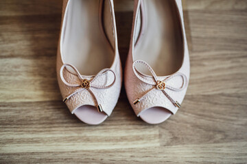 Wedding shoes with bows stand on grey floor