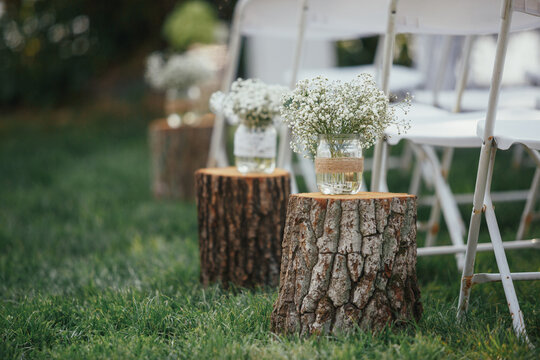 Billets of wood with bowls and flowers stand on the lawn