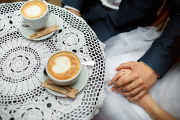 Word 'Love' written on a cup of late whitch stands before a bride