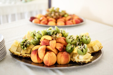 Pieces of kiwi and peaches served on the dish