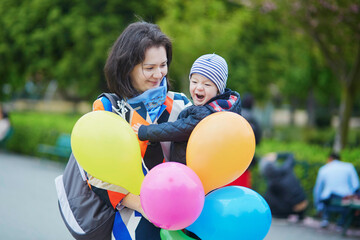 Happy family of two with bunch of colorful balloons in Paris