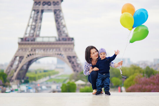 Happy family of two with bunch of colorful balloons in Paris