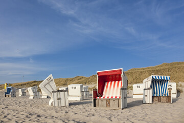 Fototapeta na wymiar Typical beach chairs at Sylt, dunes in background