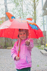 in the rain happy child with an umbrella.
