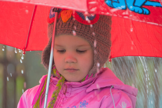 in the rain sad child with an umbrella.