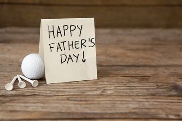 Fathers day greeting card by golf ball on table