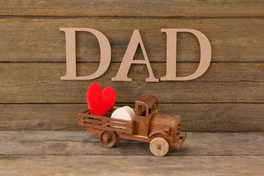 Dad text by heart shape in toy truck on table - Powered by Adobe
