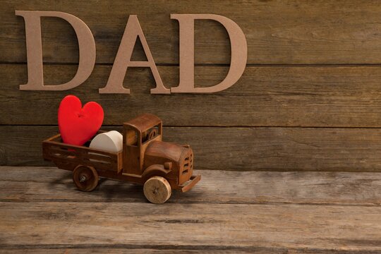 Text dad by heart shape in toy truck on table