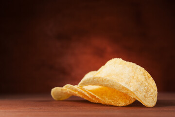 Crispy potato chips on a wooden background. Chips in the air.