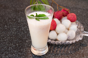 Litchi juice in a glass. Fresh juicy lychee fruit on a glass plate.