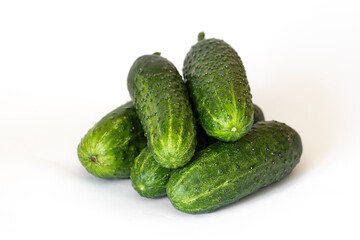 Heap of five fresh cucumbers on white background