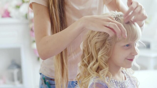 A young lady is doing an elegant hairstyle