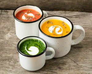 Homemade vegetarian soup made from fresh spinach pumpkin  tomatoes poured into a white mug