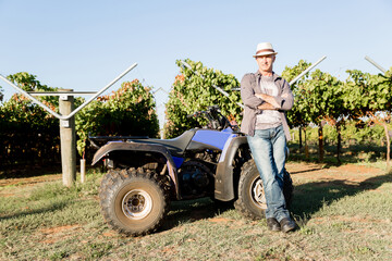Obraz premium Man standing next to truck in vineyard