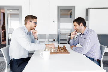 Portrait of two young man playing chess 