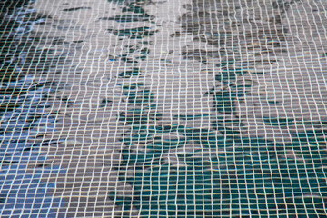 Patterns mosaic tile background in swimming pool.
