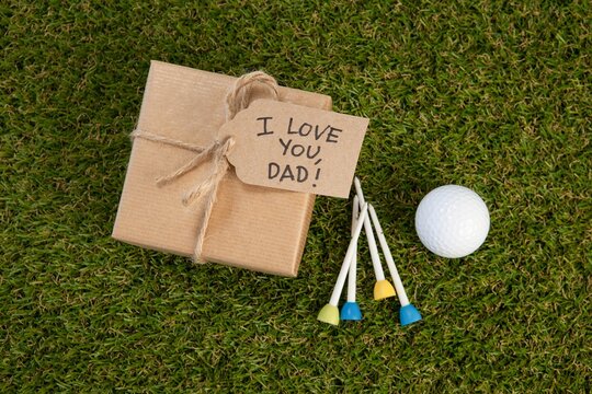 Fathers day gift box with text by golf ball on field