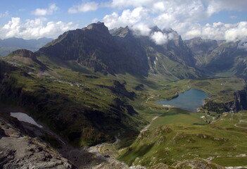 Naklejka na ściany i meble Scenic view of the Uri Alps mountain range with mount Titlis and the Truebsee lake, Switzerland