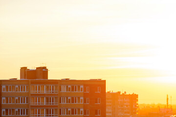 Obraz premium Photo of sunset over buildings in a warm light color tone at spring