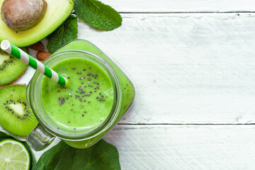 green healthy smoothie with avocado, spinach, kiwi, lime and chia seeds in a glass jar - obrazy, fototapety, plakaty