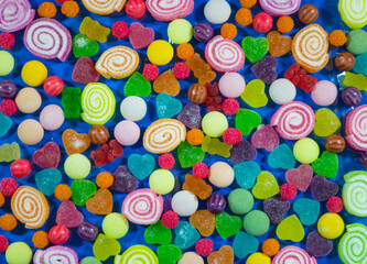 Fototapeta na wymiar Mixed colorful candies and jelly on copy space background.