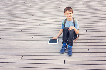 Smiling kid with tablet computer. School, education, technology, leisure concept