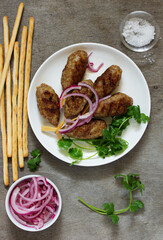 Kyufta (barbecue) of lamb with snacks (radish salad, chips and hummus.)