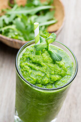 Rucola smoothie, on the grey  background.