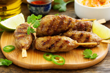 Kyufta (barbecue) of lamb with snacks (radish salad, chips and hummus.)