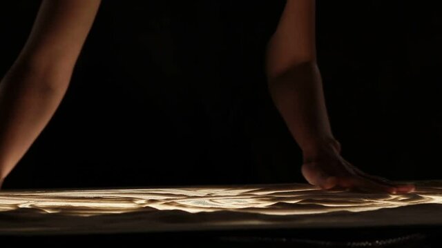 Woman's hands making sand painting