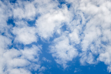 Deep blue sky texture background with white clouds and copy space.