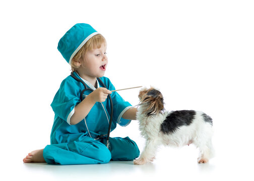 Child weared doctor clothes playing veterinarian with dog