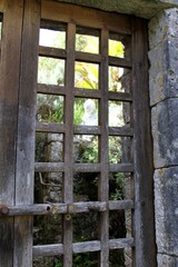 statuette de ch&eacute;rubin derri&egrave;re une porte en bois ajour&eacute;e