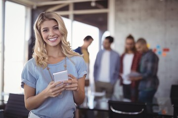 Portrait of smiling businesswoman holding mobile phone