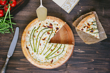 Divided asparagus pie or tart on wooden table.